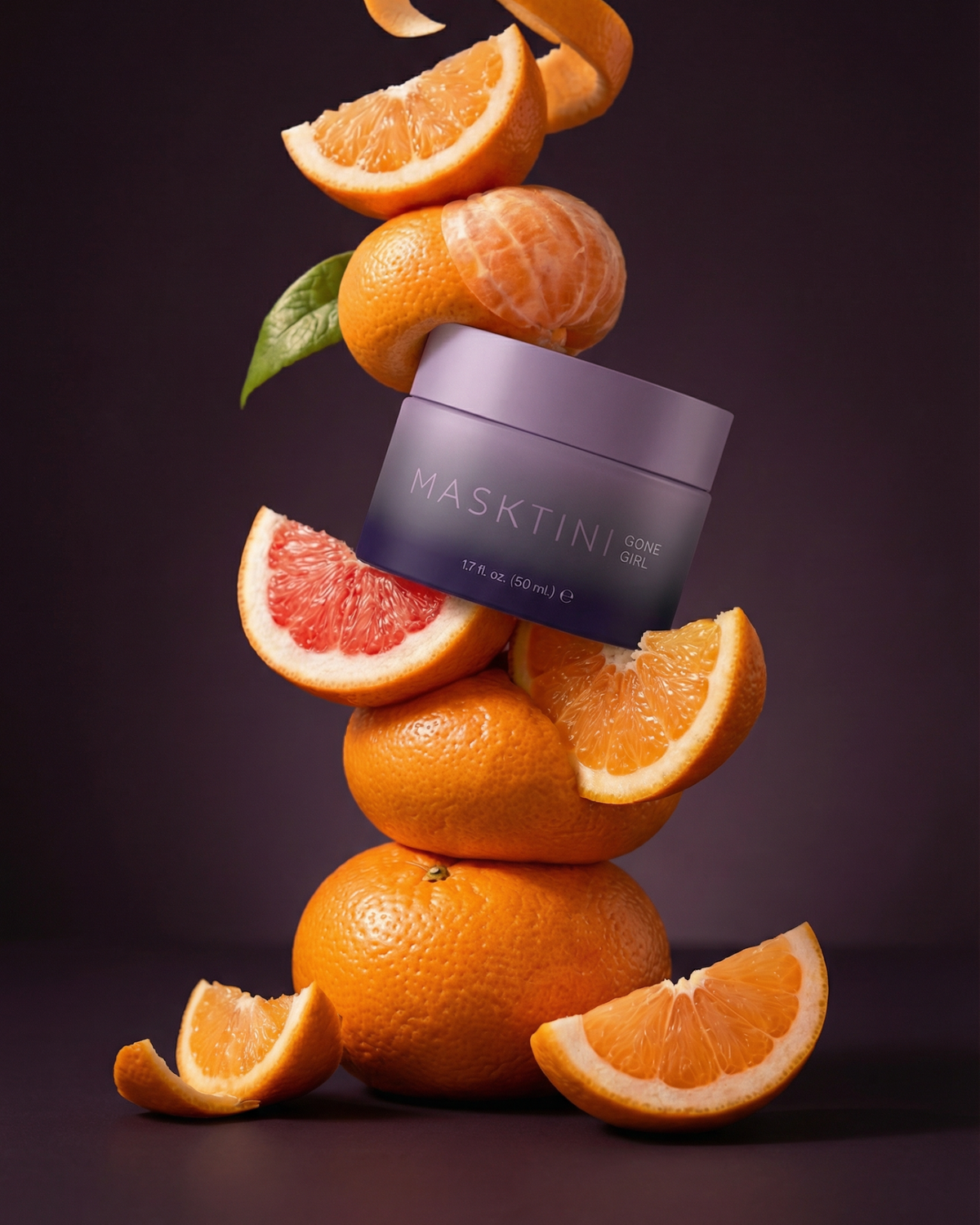 Jar of Masktini Gone Girl mask balanced among orange, grapefruit, and mandarin citrus slices