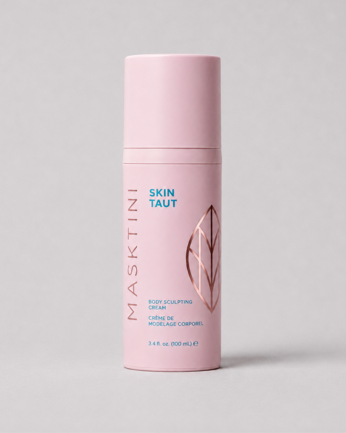 A pink cylindrical bottle of Masktini Skin Taut Body Sculpting Cream, featuring a matching pink cap, with blue and rose gold text and graphics on a neutral gray background.